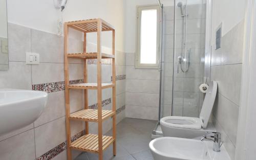 a bathroom with a toilet and a sink and a shower at Alta Marea B&B in Porto Empedocle