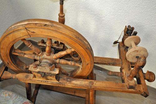an old wooden spinning wheel sitting on a table at Landhaus Riesneralm in Donnersbachwald