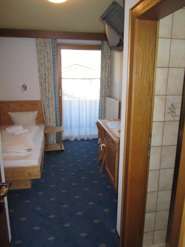 a room with a bathroom with a bed and a sink at Appartement Alpenhof Wildschönau in Niederau
