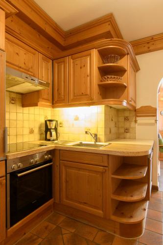 a kitchen with wooden cabinets and a sink at Alpasella Ferienwohnungen in Sankt Gallenkirch
