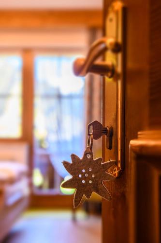 a wooden door with a metal key on it at Alpasella Ferienwohnungen in Sankt Gallenkirch