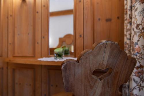 a wooden chair with a heart carved into it at Alpasella Ferienwohnungen in Sankt Gallenkirch