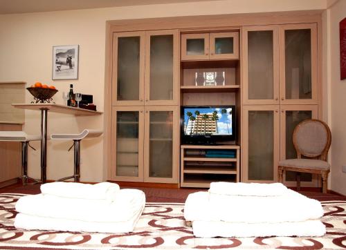 ein Wohnzimmer mit 2 weißen Sofas und einem TV in der Unterkunft Ithaki Phinikoudes Apartment 307 in Larnaka