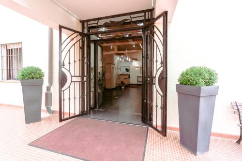 an open door to a hallway with two potted plants at Le Terrazze in Follonica
