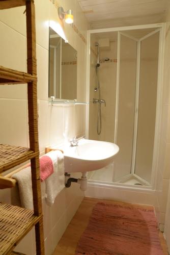 y baño blanco con lavabo y ducha. en La Petite Passerelle à Mouzaive, en Vresse-sur-Semois