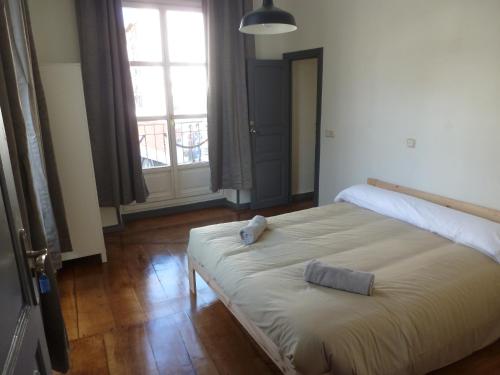 1 dormitorio con 1 cama grande y 2 toallas. en Hostal del Arquitecto en Vitoria