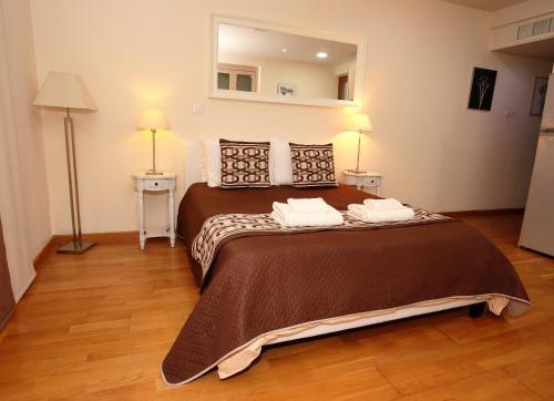 1 dormitorio con 1 cama grande y 2 toallas. en Ithaki Phinikoudes Apartment 307, en Lárnaca
