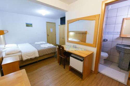 a bedroom with a bed and a bathroom with a sink at Hotel 13 Linden in Treze Tílias