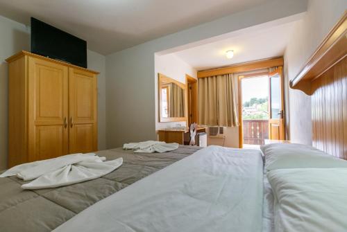 a bedroom with a bed with towels on it at Hotel 13 Linden in Treze Tílias