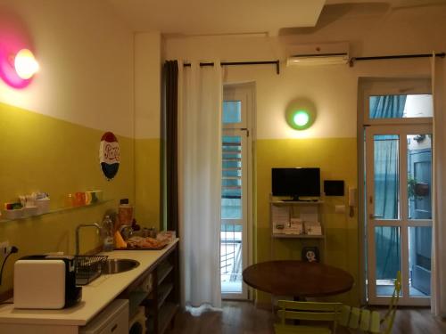 a kitchen with green walls and a table and a window at Ca'cita Guest House Torino in Turin