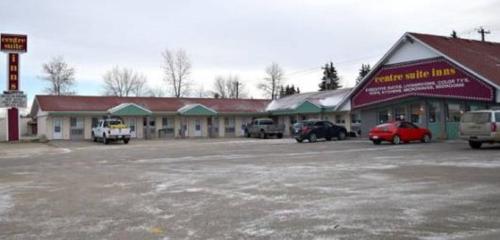 un edificio con coches estacionados en un estacionamiento en Centre Suite Inns Motel, en Bonnyville