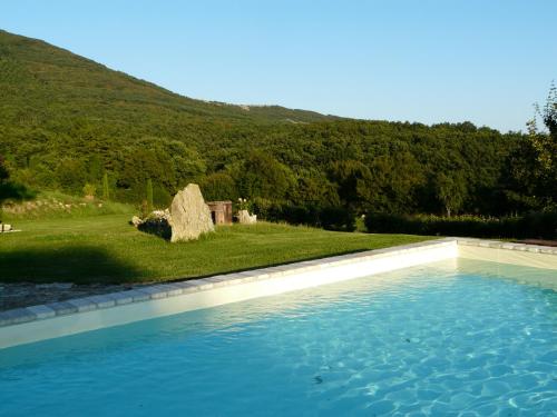 a large swimming pool in a yard with a hill at Il Borgo Del Lupo Relax Family Apartments in Tuscany with Restaurant & Swimming Pool in Sarteano