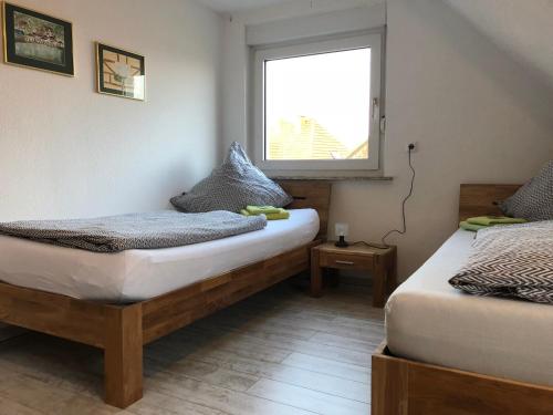 2 camas en una habitación con ventana en FeWo 01 Bettenhausen, en Morschen