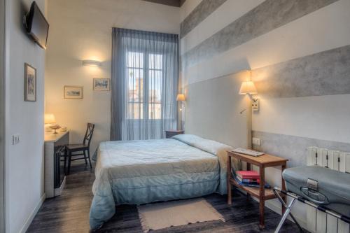ein Hotelzimmer mit einem Bett, einem Tisch und einem Schreibtisch in der Unterkunft Al Bastione di Cagliari in Cagliari