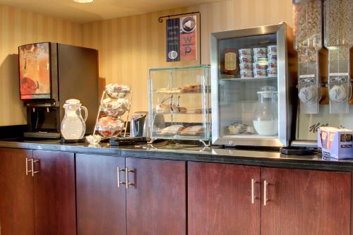 a kitchen with a counter top with a refrigerator and a counter at Cobblestone Inn & Suites - Carrington in Carrington