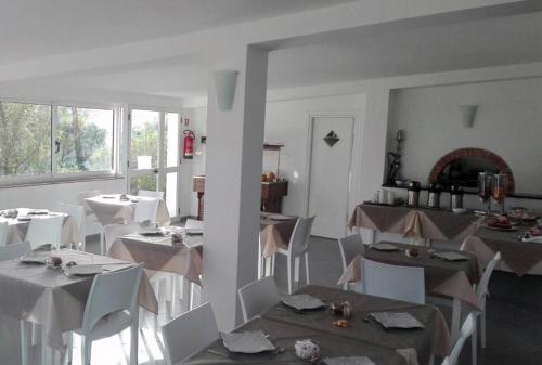 a dining room with white tables and white chairs at Oasi Di Casablanca in Lampedusa
