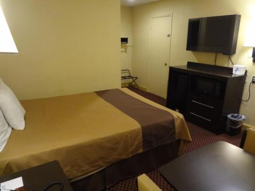 a hotel room with a bed and a flat screen tv at Americas Best Value Inn - Goldsboro in Goldsboro