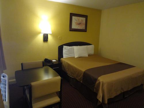 a hotel room with a bed and a chair at Americas Best Value Inn - Goldsboro in Goldsboro