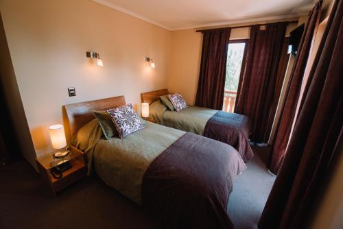 um quarto de hotel com duas camas e uma janela em Hotel Chalet Valluga em Farellones