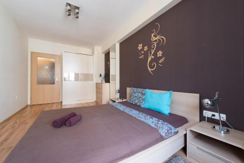 Un dormitorio con una cama grande con almohadas azules. en City Apartments, en Sofía
