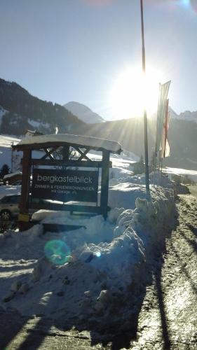 a bench in the snow with the sun behind it at Haus Bergkastelblick in Nauders