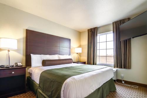 a hotel room with a large bed and a window at Castle Rock Inn & Suites - Quinter in Quinter