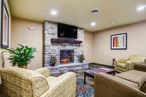 a living room with couches and a fireplace at Castle Rock Inn & Suites - Quinter in Quinter