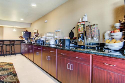 a kitchen with wooden cabinets and a counter top at Castle Rock Inn & Suites - Quinter in Quinter
