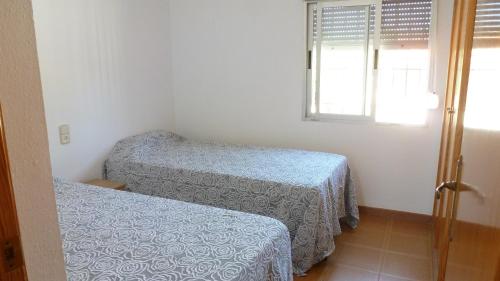 a small room with two beds and a window at Chalet Verde in Tavernes de Valldigna