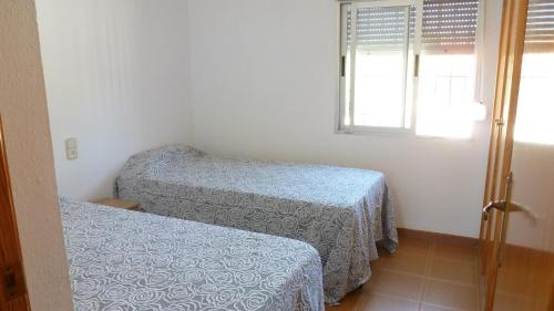 タベルネス・デ・ラ・バルディグナにあるChalet Verdeのベッド2台と窓が備わる小さな客室です。