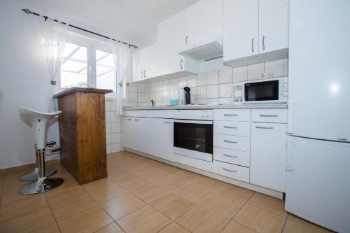 a kitchen with white cabinets and a white refrigerator at Apartments Dania in Lopar