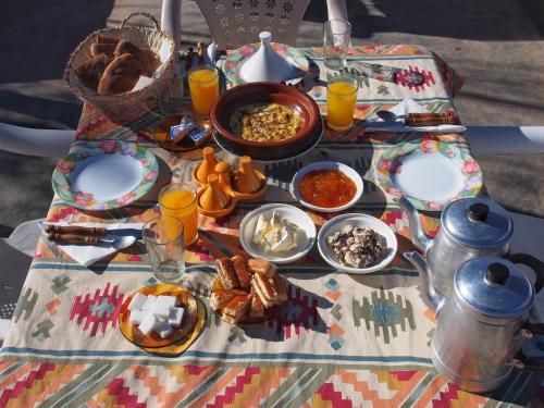 una mesa con platos de comida y bebidas. en Auberge Tafouyt, en Tamtetoucht