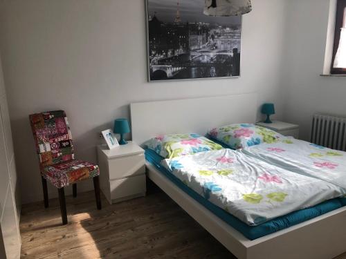 a small bedroom with a bed and a chair at Ferienwohnung Liebing in Bad Sachsa
