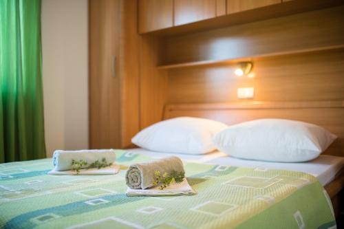 a bed with two towels on top of it at Apartments Dania in Lopar
