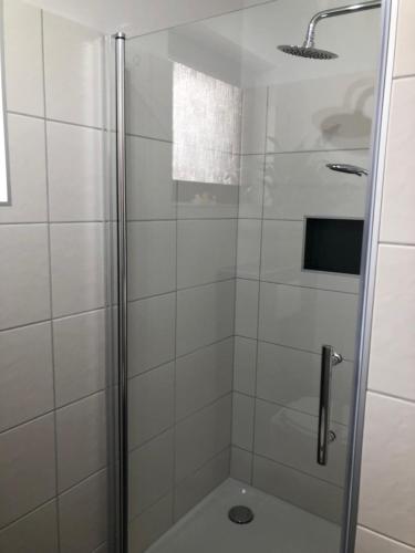 La salle de bains est pourvue d'une douche avec une porte en verre. dans l'établissement Ferienwohnung Liebing, à Bad Sachsa