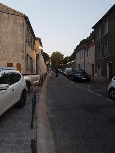 a street with cars parked on the side of the road at Gîtes Les 3 Tours 2 in Carcassonne
