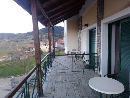 a balcony with tables and chairs on a building at Elikonio in Agia Anna