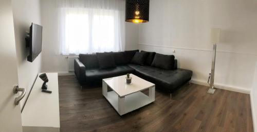 a living room with a black couch and a table at Hugo18 Boardinghouse in Kandel