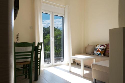 a living room with a table and a window at Villa Albanis in Kolios