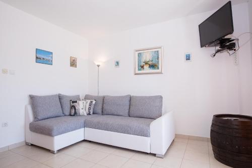 a living room with a couch and a flat screen tv at Apartments Dania in Lopar