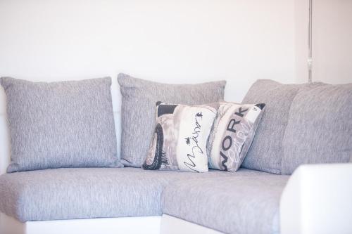 a gray couch with pillows on top of it at Apartments Dania in Lopar