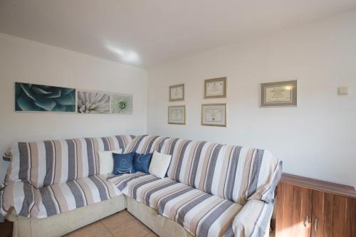 a living room with a couch with blue pillows at Apartments Dania in Lopar