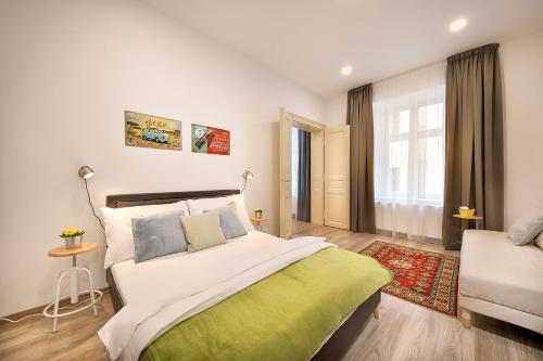 a bedroom with a large bed and a couch at Luxurious Apartments Karlin in Prague