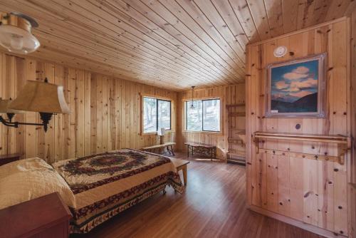 ein Schlafzimmer mit einem Bett in einem Zimmer mit Holzwänden in der Unterkunft Silver City Mountain Resort in Sequoia
