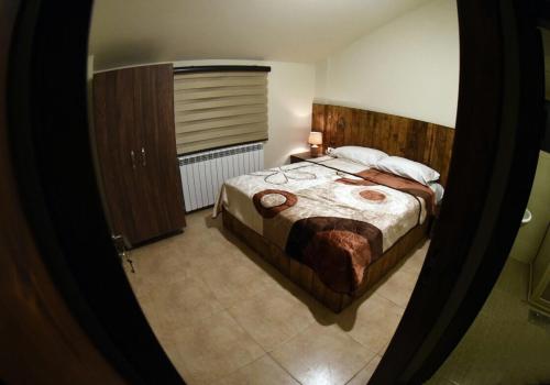 a bedroom with a large bed with a wooden headboard at Villars in Mayrūbā
