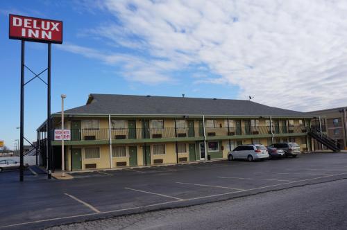a building with cars parked in a parking lot at Delux Inn Tulsa in Tulsa