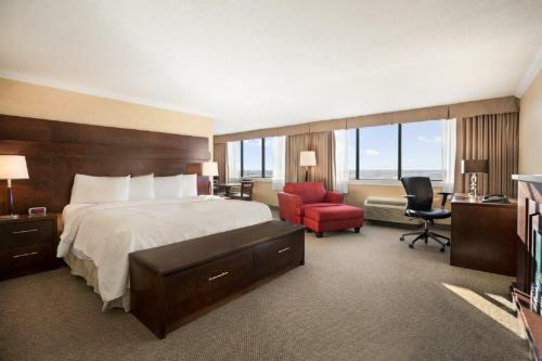 a hotel room with a bed and a desk and a chair at The Senator Hotel & Conference Center Timmins in Timmins