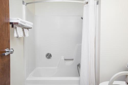 a bathroom with a shower with a white shower curtain at Super 8 by Wyndham Clear Lake in Clear Lake