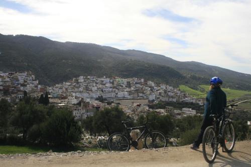 a person on a bike looking at a city at Dar Zerhoune in Moulay Idriss Zerhoun