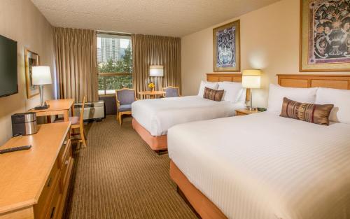 a hotel room with two beds and a television at Hotel 116, A Coast Hotel Bellevue in Bellevue